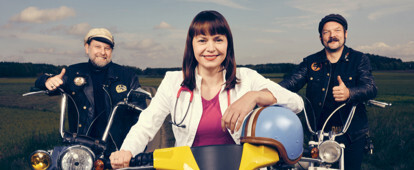 Landärztin sitzt auf einer gelben Schwalbe. Links und rechts von ihr zwei Biker.